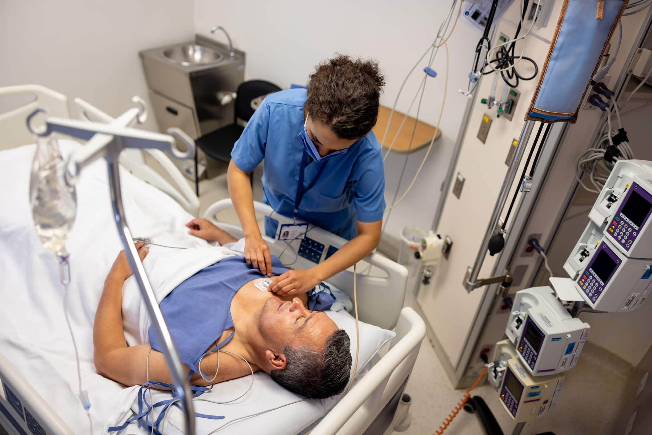 Nurse placing electrodes on a patient at the hospital